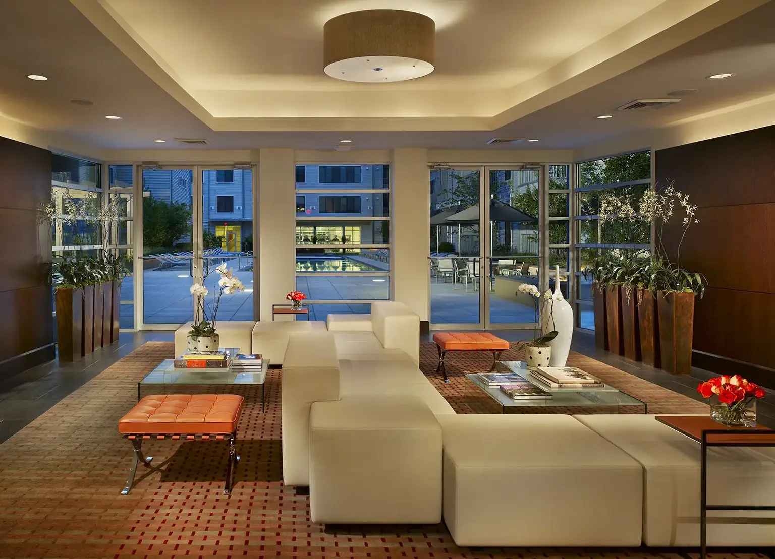 AVE Union apartment building lounge with orange comfy chairs, and large windows to exterior courtyard