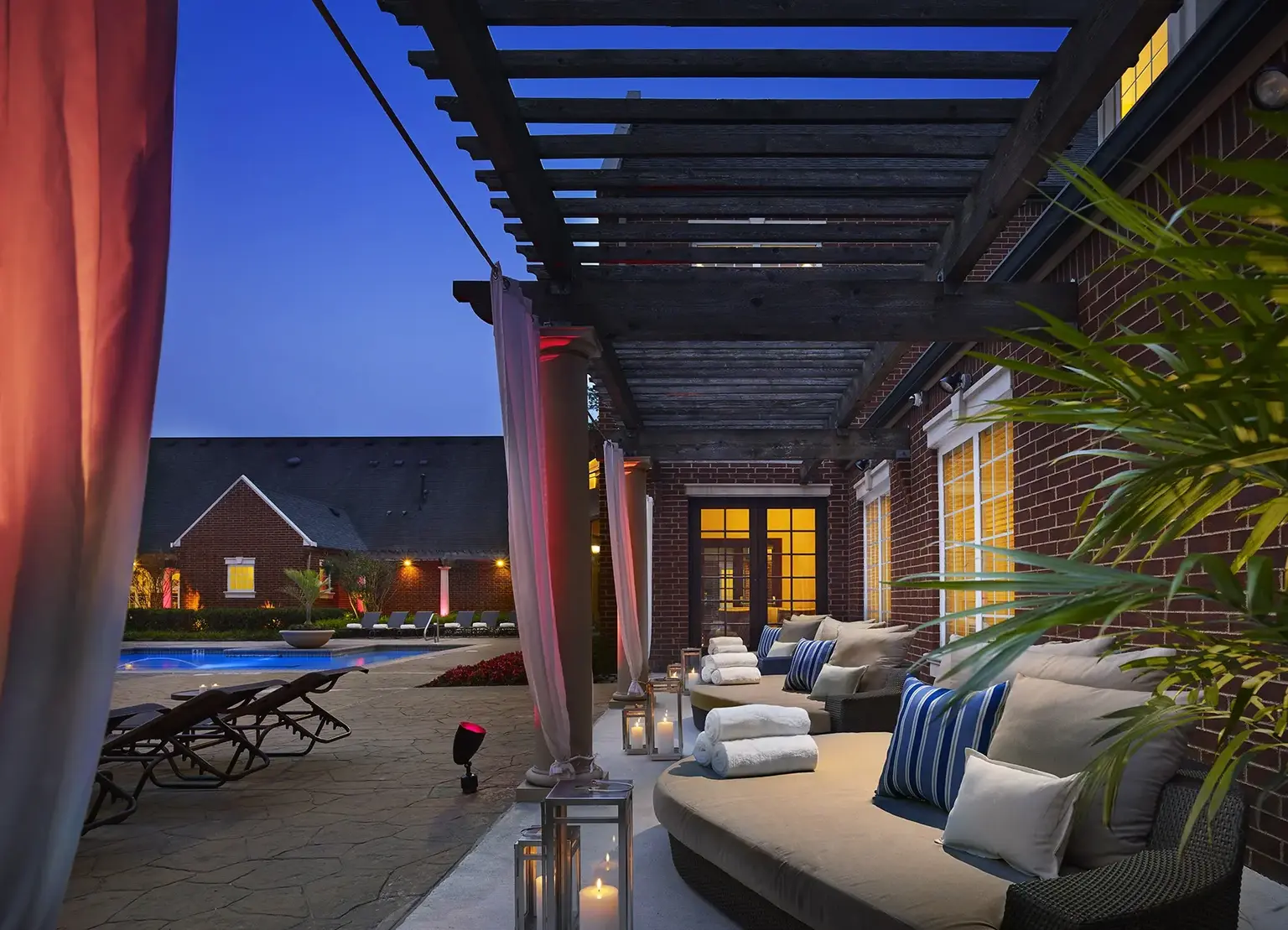 AVE Somerset apartment community with draped cabana by pool at dusk