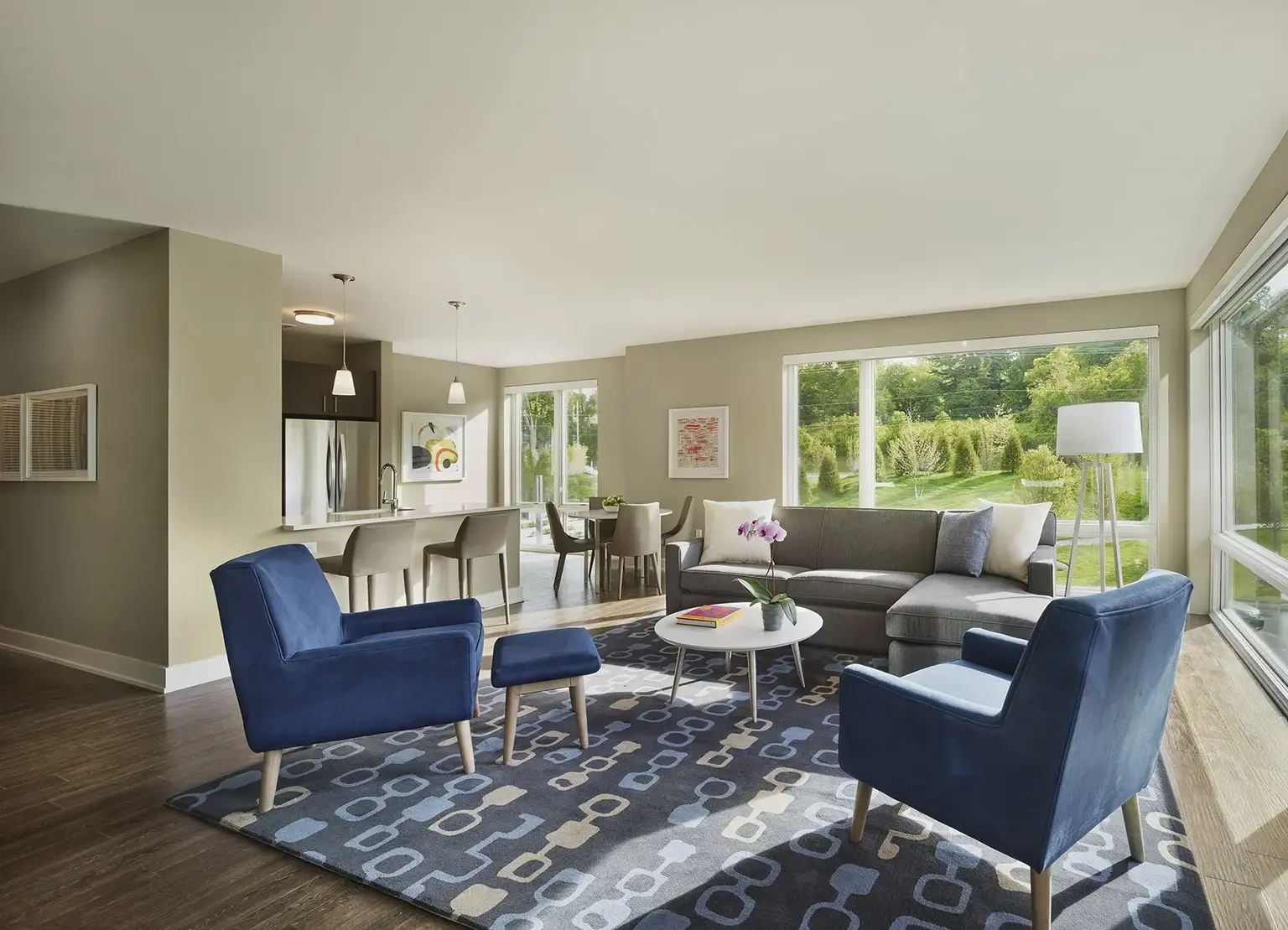 AVE Florham Park furnished corner apartment with large windows, blue couch and chair, and modern rug