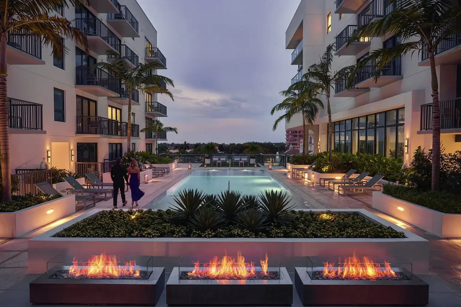 AKA West Palm Outdoor Pool with fireplaces at sunset