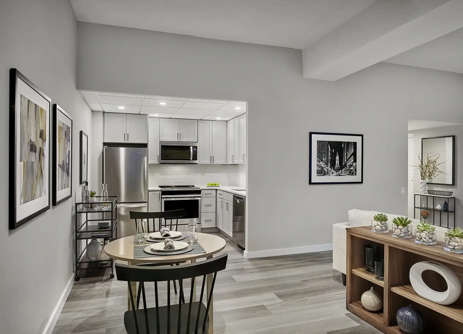 Renovated Philadelphia furnished apartment with kitchen off living room, bookcase and bistro table in the center