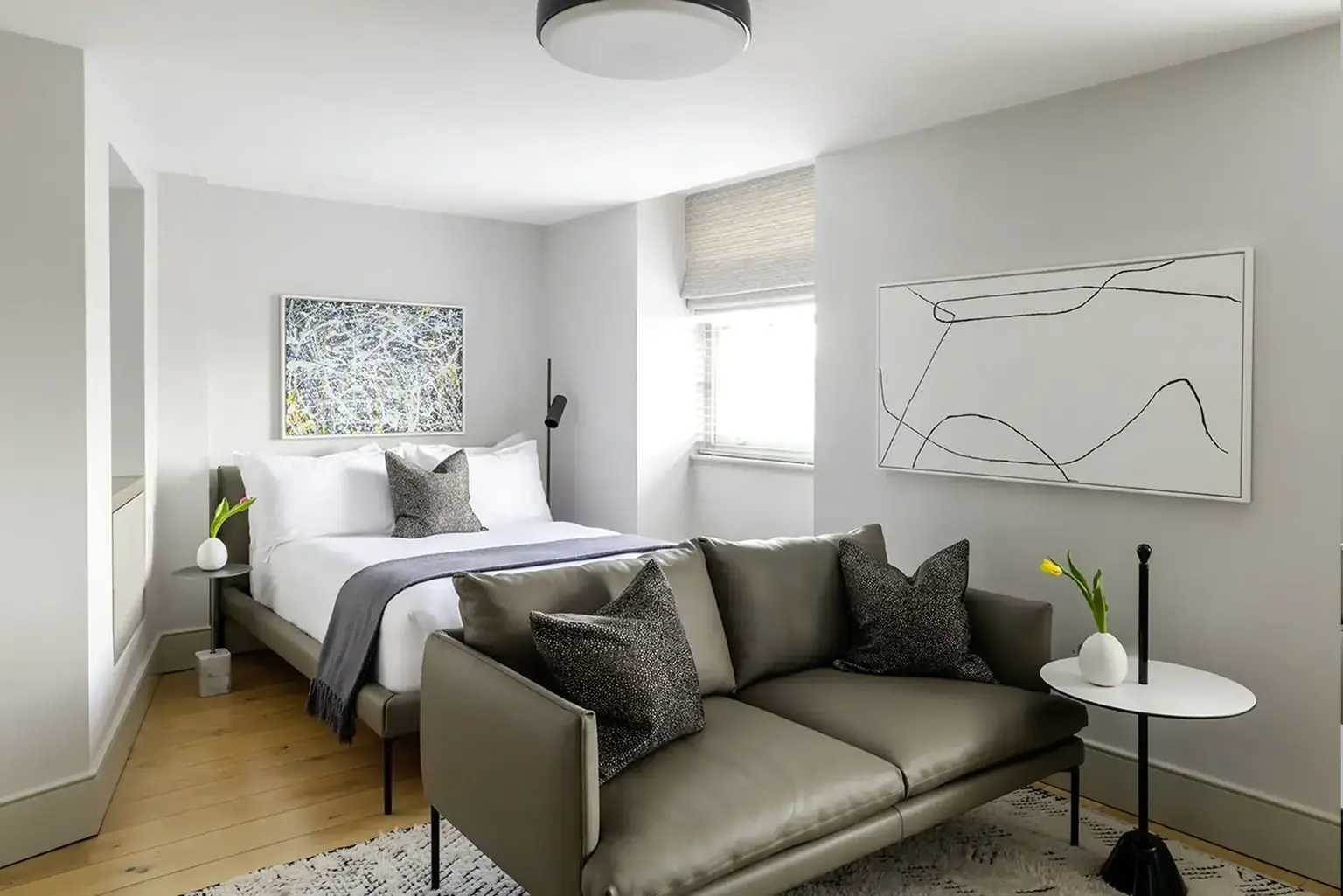 AKA Marylebone furnished apartment bedroom with king bed, yellow blinds, and luxury chairs