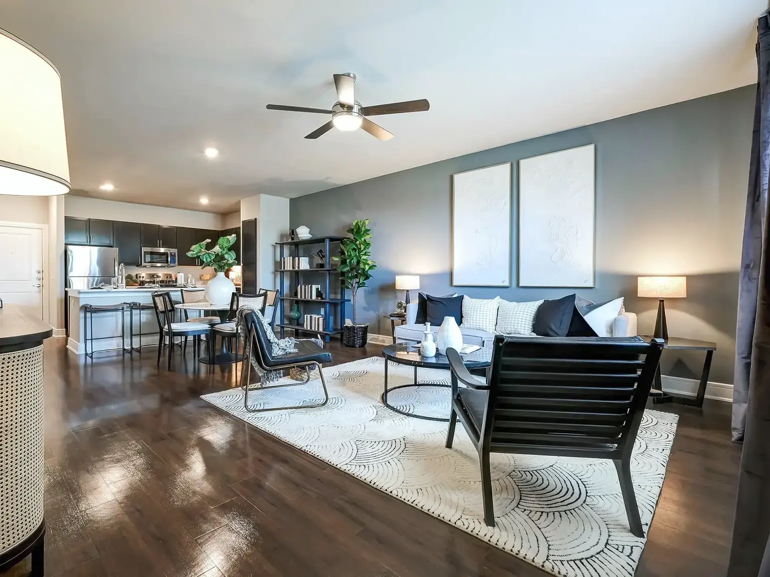 Furnished apartment living room with view of open kitchen and dining area at AVE Las Colinas.