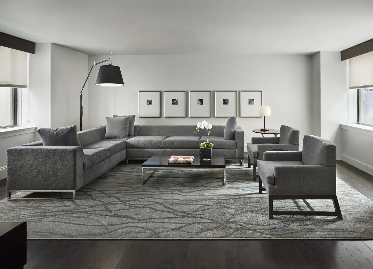 AKA Central Park furnished apartment living room with gray couch and chairs on floor rug