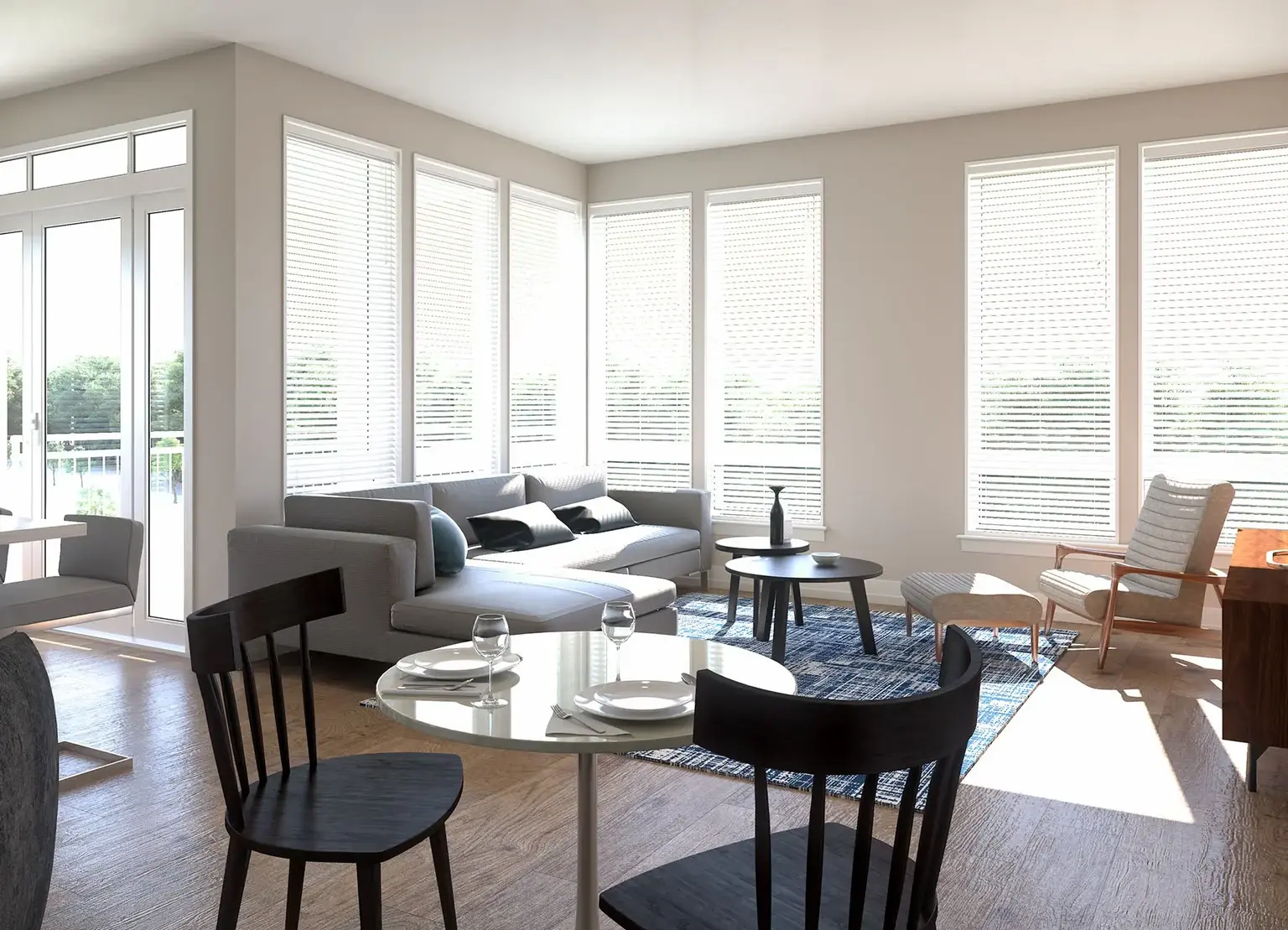 AVE Blue Bell apartment living room with natural light through large windows, high end gray furniture, and a rug