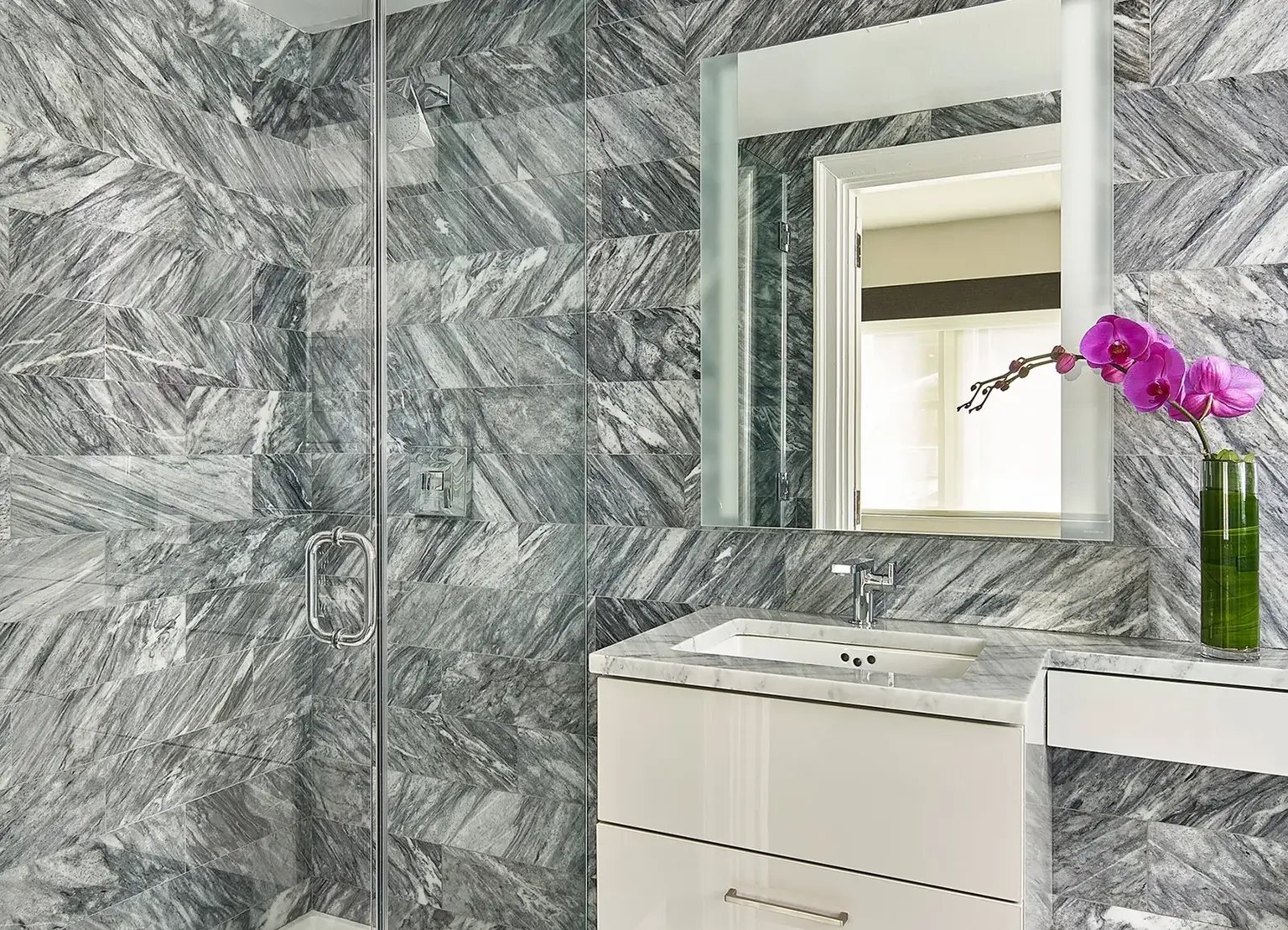 AKA Central Park furnished apartment bathroom with marble details, vanity, and shower
