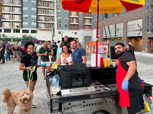 A group of people in front of the grill posing for a photo